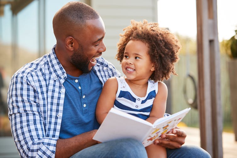 Father reads to small daughter