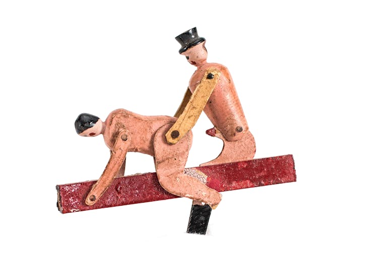 Naked wooden figures in a sexual postiion.