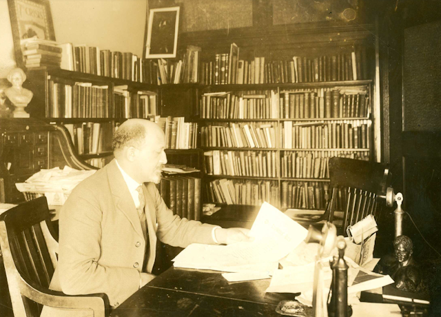 W.E.B. Du Bois seated at desk in office