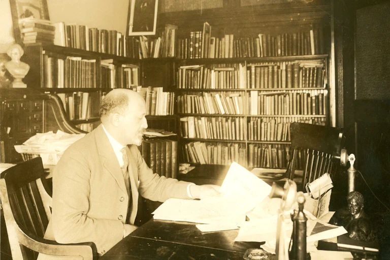 W.E.B. Du Bois seated at desk in office