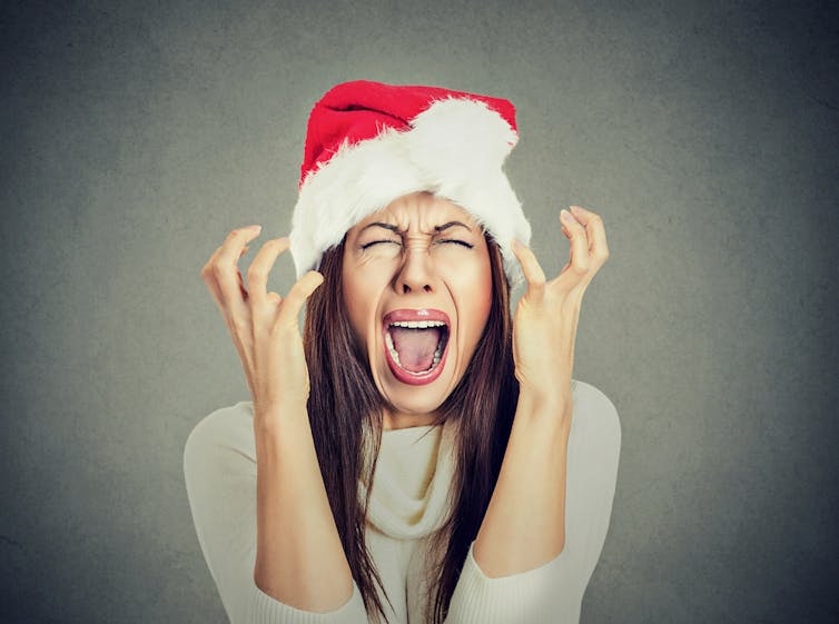 Woman screaming wearing Santa hat