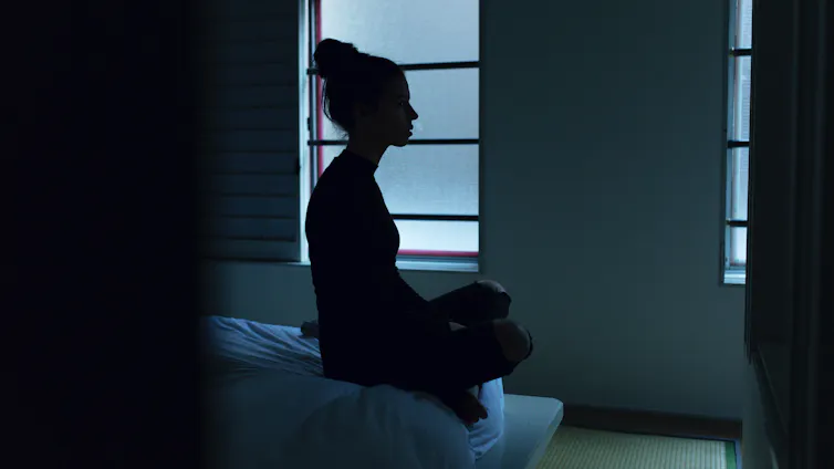 A woman's silhouette in the darkness.