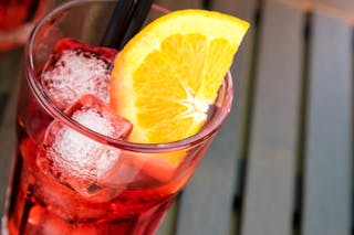 Boisson rouge rafraîchissante dans un verre avec des glaçons et du citron
