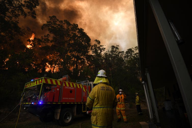 A Fire and Rescue crew worker trying to protect property set alight in NSW.