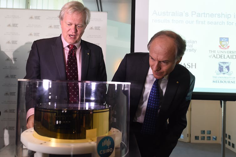 Brian Schmidt and Alan Finkel look at an ultra high-performance optical mirror used to detect gravitational waves.