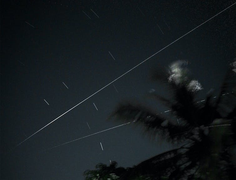 Flash of two meteors across a night sky.