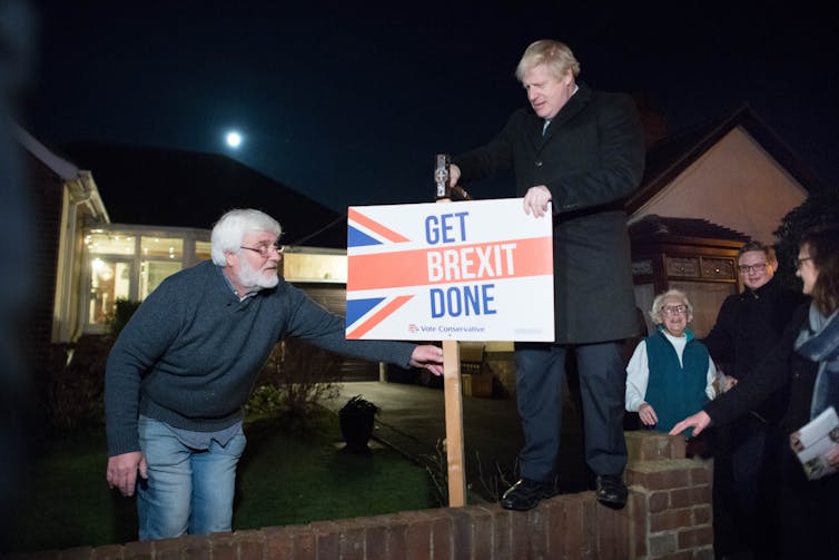 Boris Johnson pictured during the 2019 election campaign hammering a sign reading 'Get Brexit Done' into the ground.