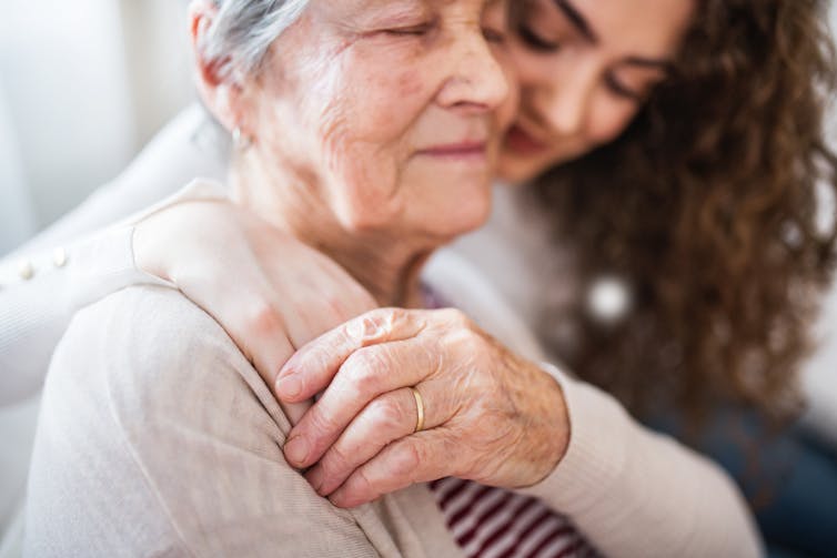 Teenage girl hugging grandmother