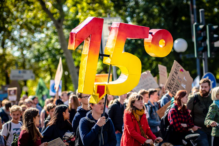 A protester holds a giant 1.5 degree sign.