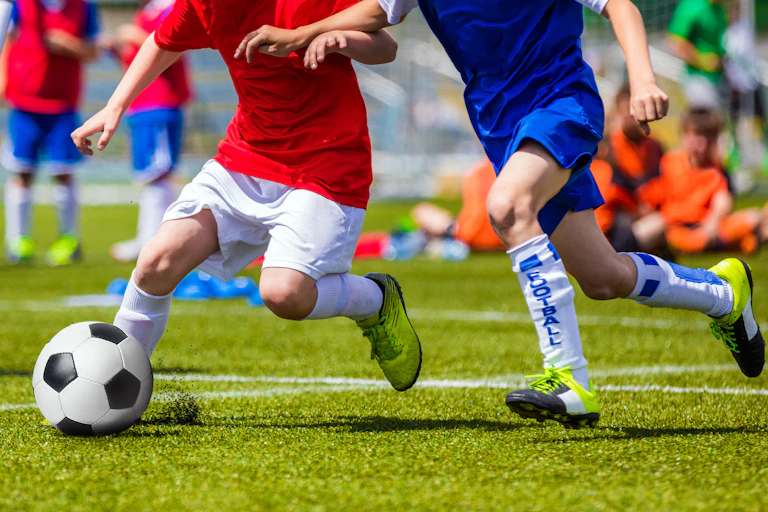 A group of children playing football at a training session.