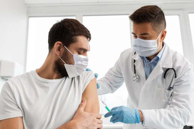 A nurse administering a vaccine to a man