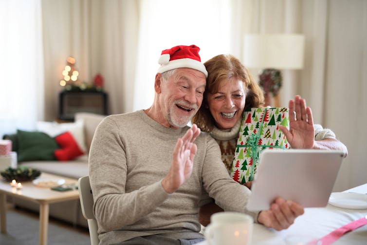 Older couple having a zoom chat at Christmas.