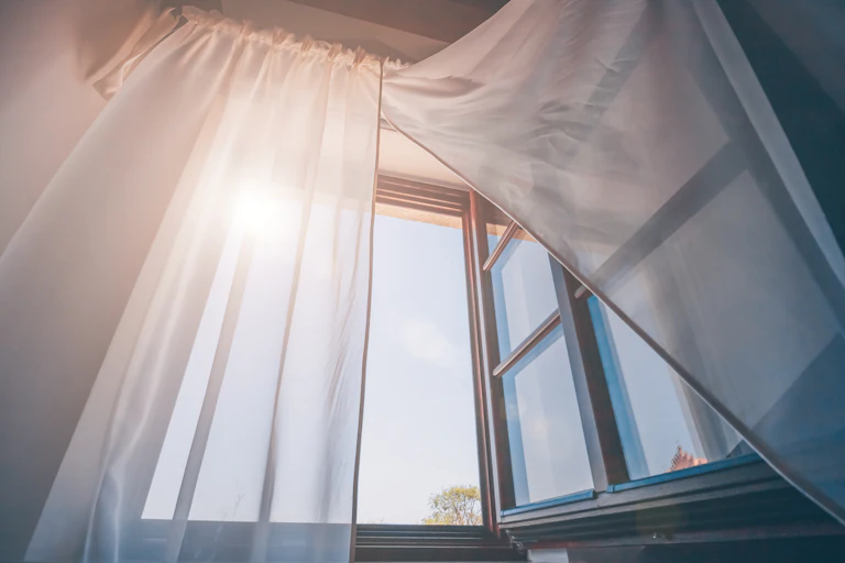 Window open with blowing curtains