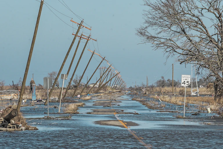 A flooded road lined by collapsing pylons