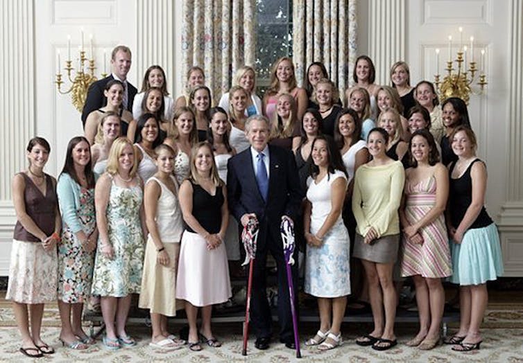 Group of young women meet the US President Bush, some are wearing thongs with formal dresses.