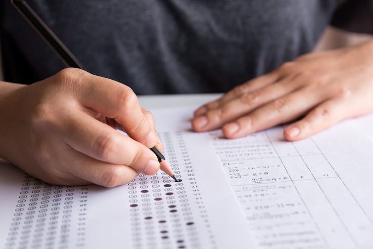 Student filling out multiple-choice answer form.