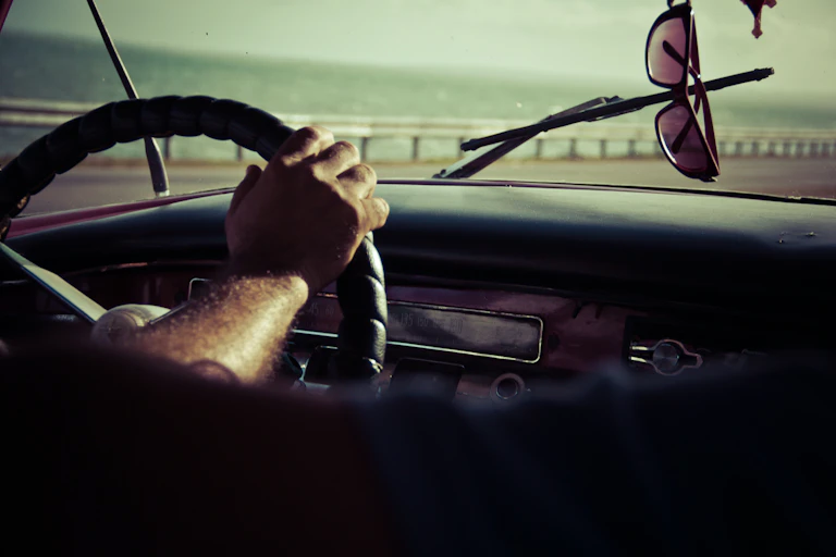 Driver at wheel with dash and sunnies