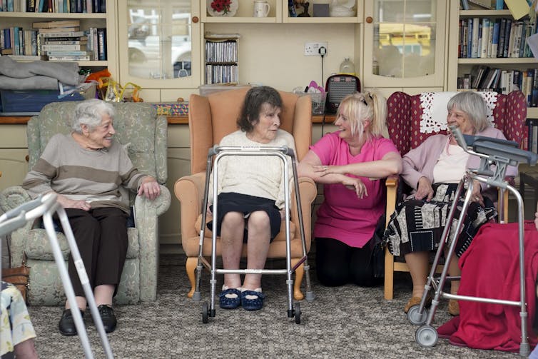 A care worker and residents talking in a care home