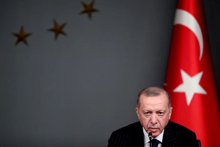 Turkish president Recep Tayyip Erdogan sits in front of a Turkish flag during a press conference in Istanbul, October 2020