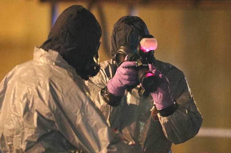 Two police investigators with protective clothing.