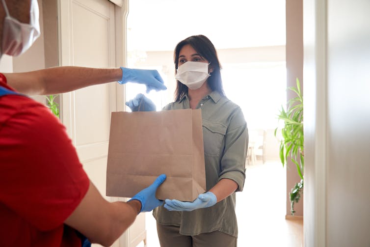 Woman receiving food delivery.