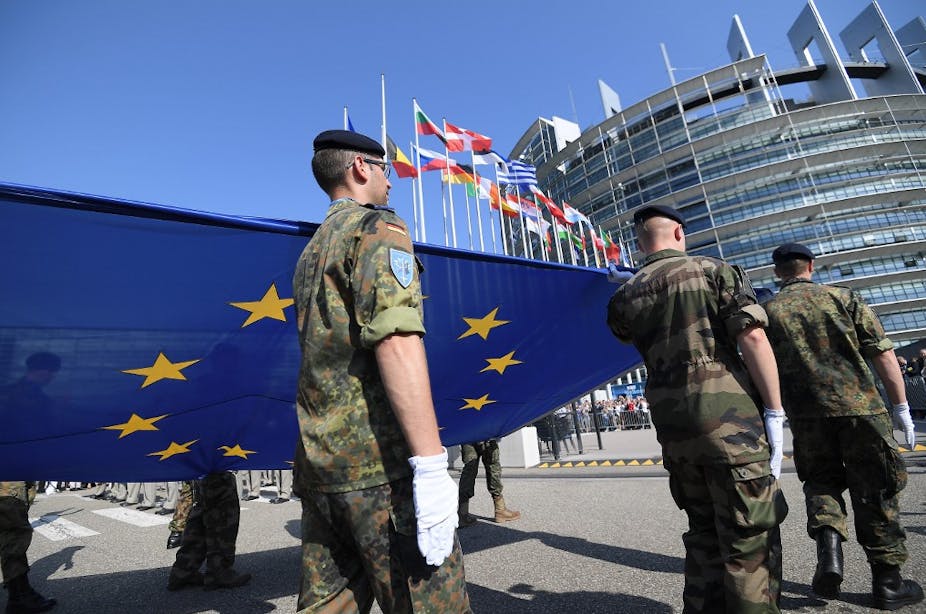 Les soldats de l'Eurocorps portent un drapeau de l'Union européenne.