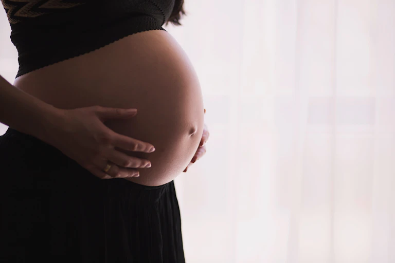 Pregnant woman holding her bump.