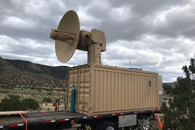 A dish antenna on a movable mount in a desert