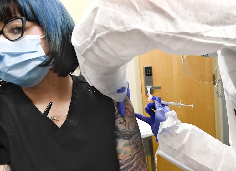 A healthcare worker receiving a COVID-19 vaccine.