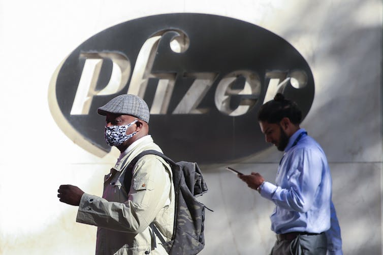 Two men in front of Pfizer headquarters in New York City.