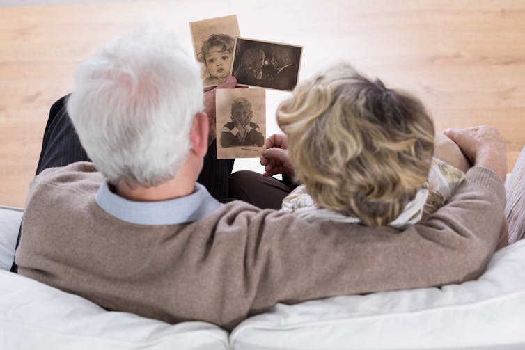 Image of an elderly couple looking at old photos.