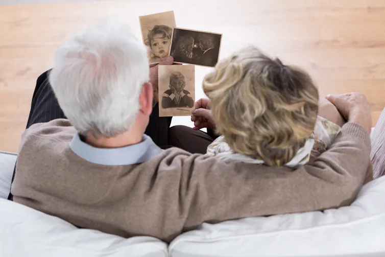 Image of an elderly couple looking at old photos.