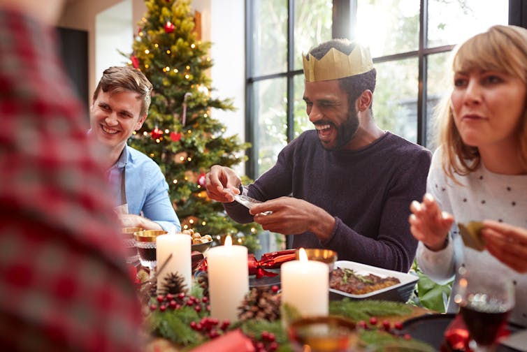 Friends gathered around the table for a Christmas meal.