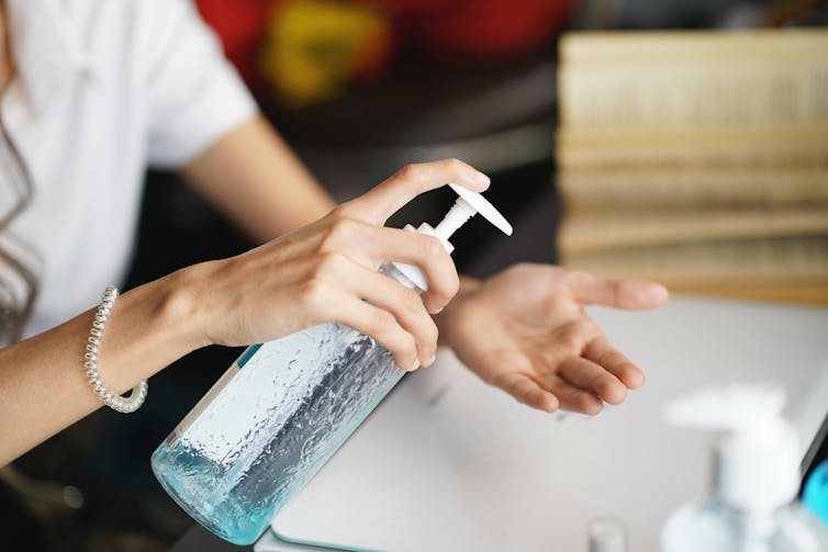 A woman uses hand sanitiser.