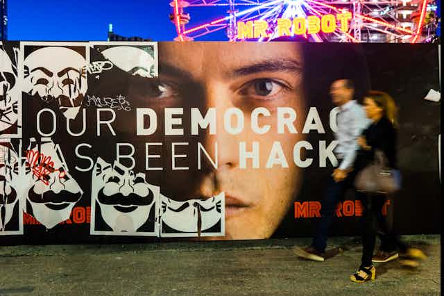 A poster of Mr Robot and two people walking in front of it at SXSW festival 2016