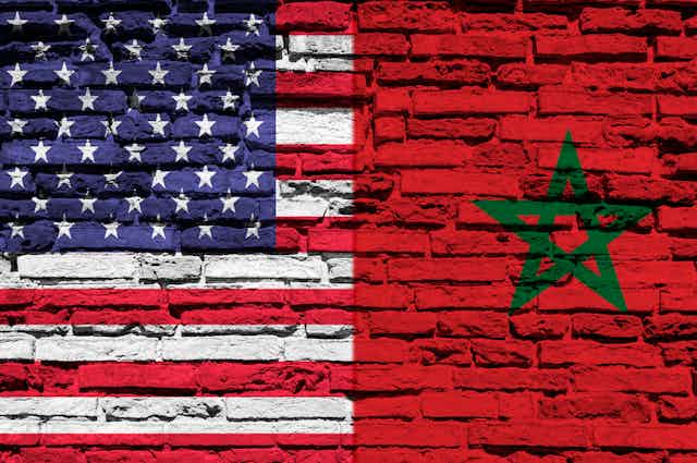 las banderas de Estados Unidos y Marruecos pintadas sobre un muro de ladrillo.