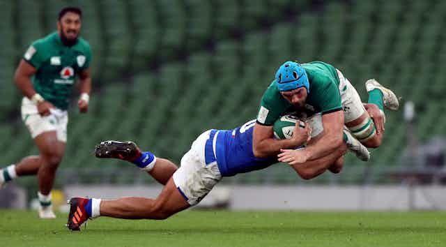 A rugby player tackled mid-air.