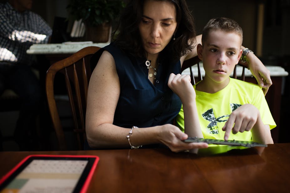 Woman and boy work together with a keyboard and iPad