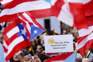 Banderas y letreros puertorriqueños sobre una multitud