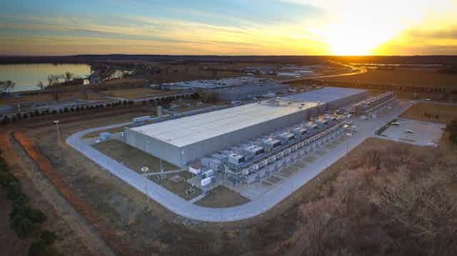 Aerial view of a massive warehouse-like structure with massive HVAC units along one side