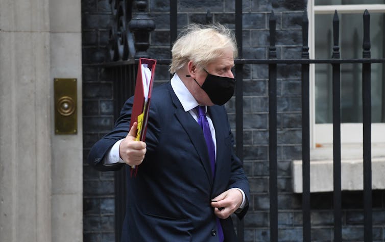 Prime Minister Boris Johnson leaving number 10 Downing Street, wearing a black mask.