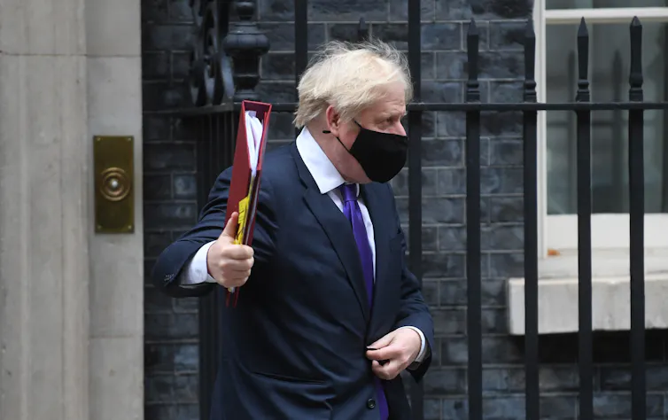 Prime Minister Boris Johnson leaving number 10 Downing Street, wearing a black mask.