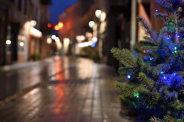 árbol de navidad con bolas azules en una calle desierta.
