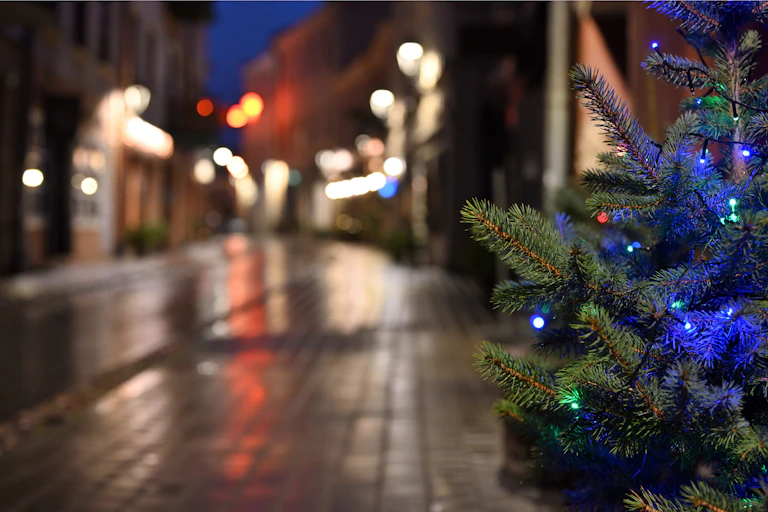 árbol de navidad con bolas azules en una calle desierta.