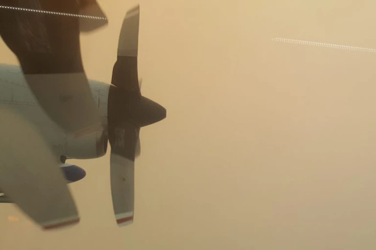 The view from the airplane window while flying through smoke.