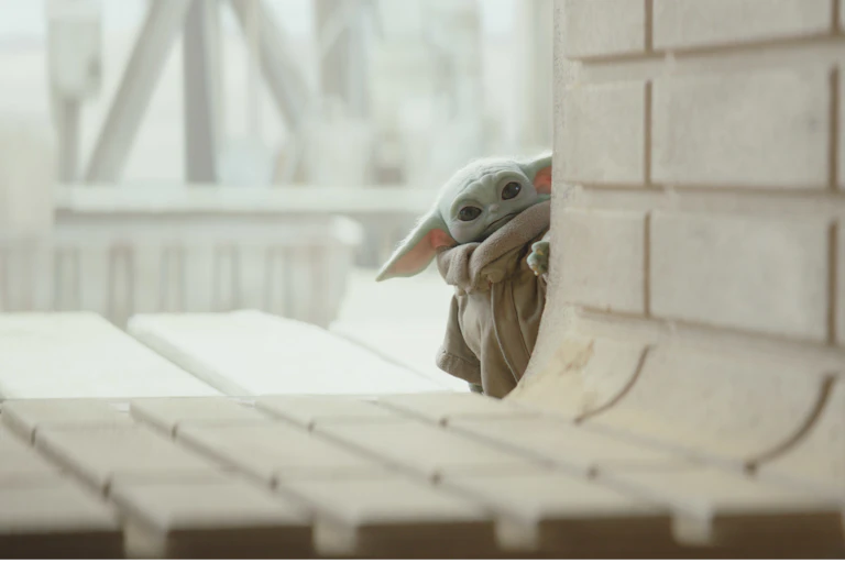 Baby Yoda peers through a spaceship entry.