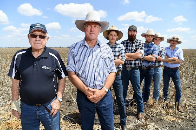 Three generations of a farmers stand on their land