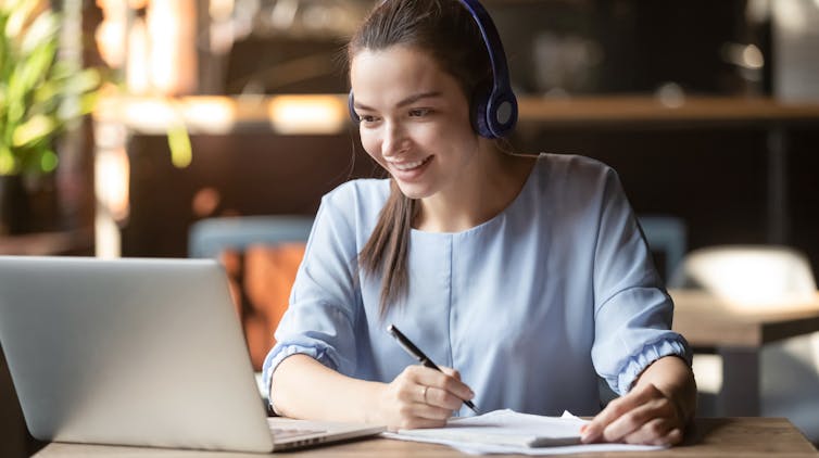 young woman smiles at her teacher during an online lecture