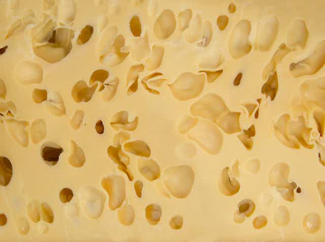 Primer plano de queso con agujeros.