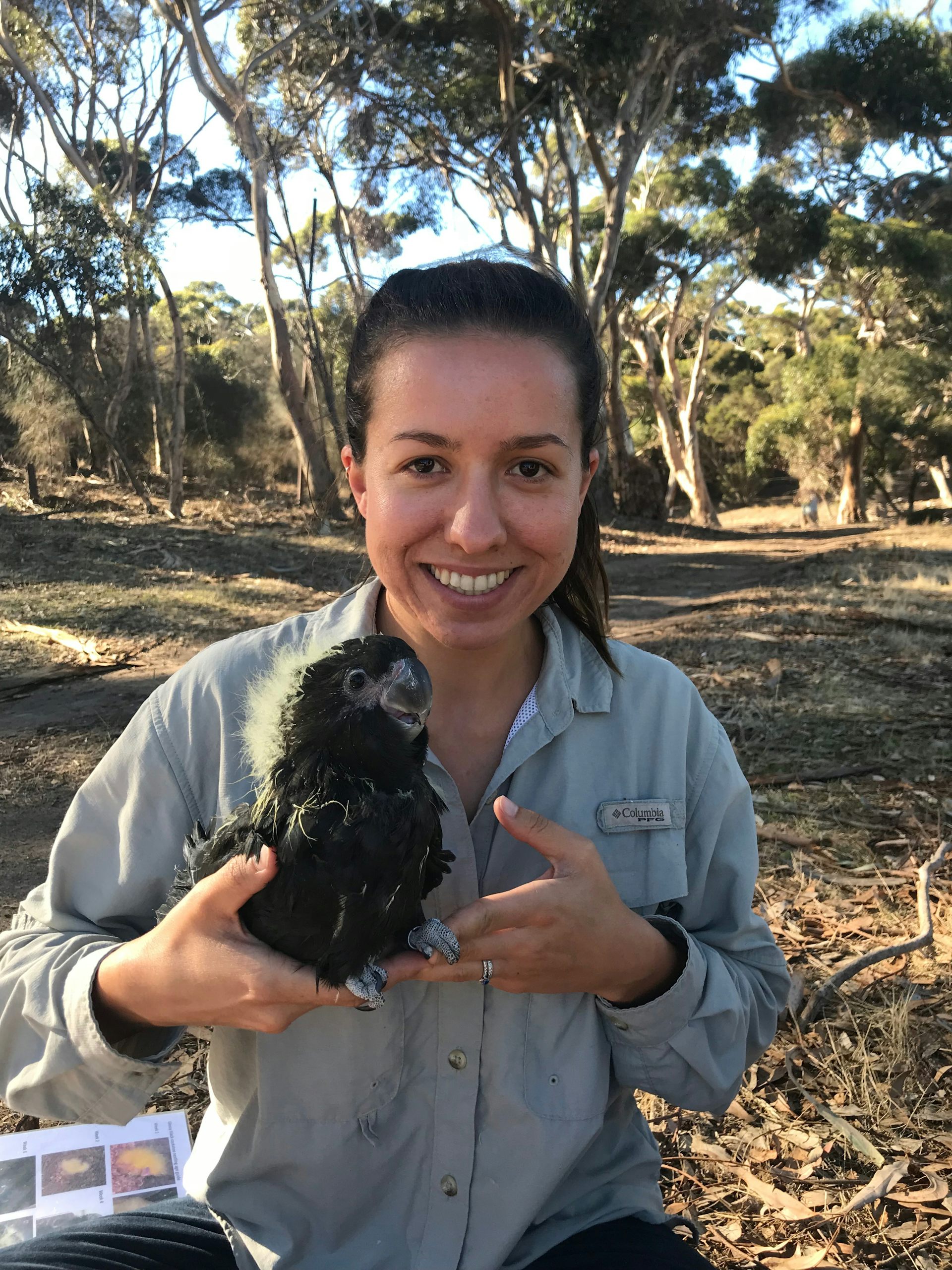 The author, Danielle Teixeira, with a glossy black cockatoo.